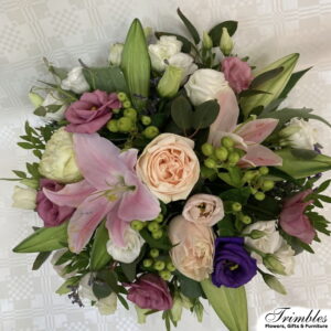 Exquisite hand-tied bouquet with pink lilies, pink roses, and hints of purple and white.